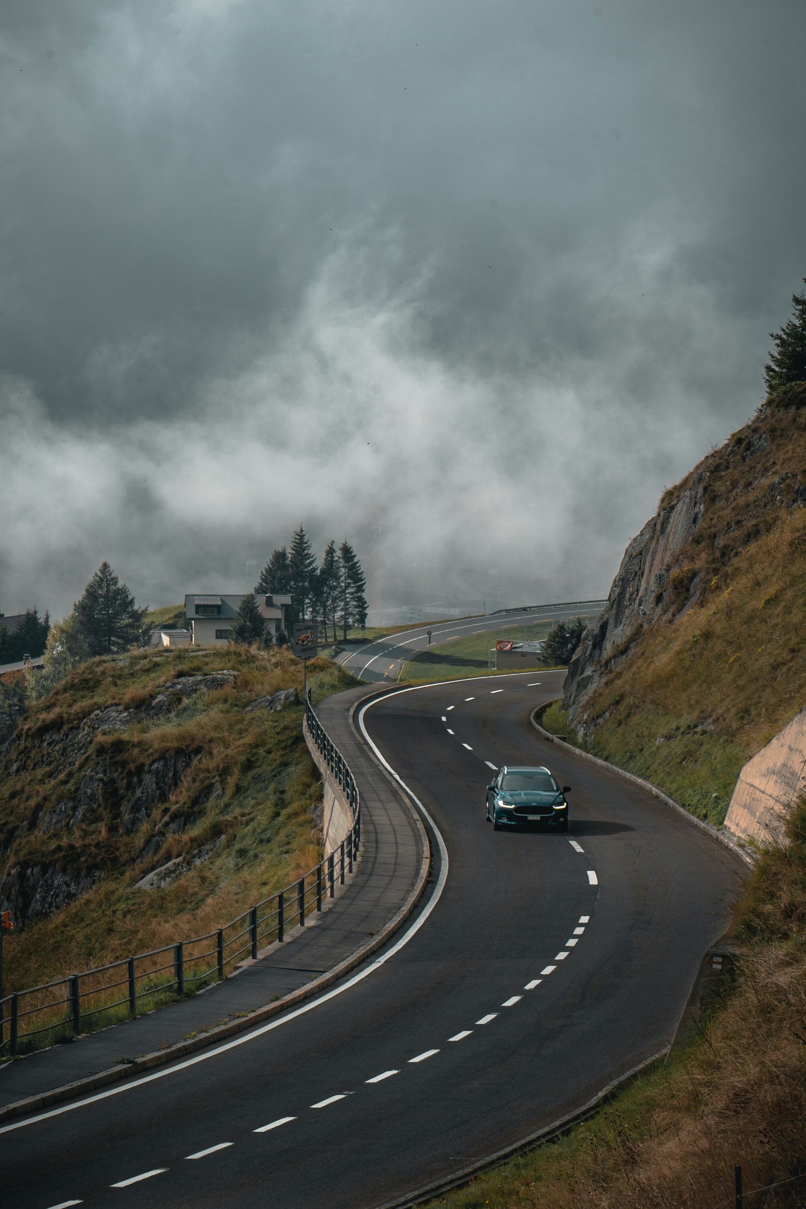 Winding road through hills under a cloudy sky