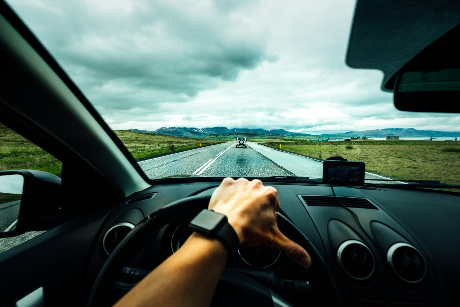 Driver with hands on the steering wheel on an open road