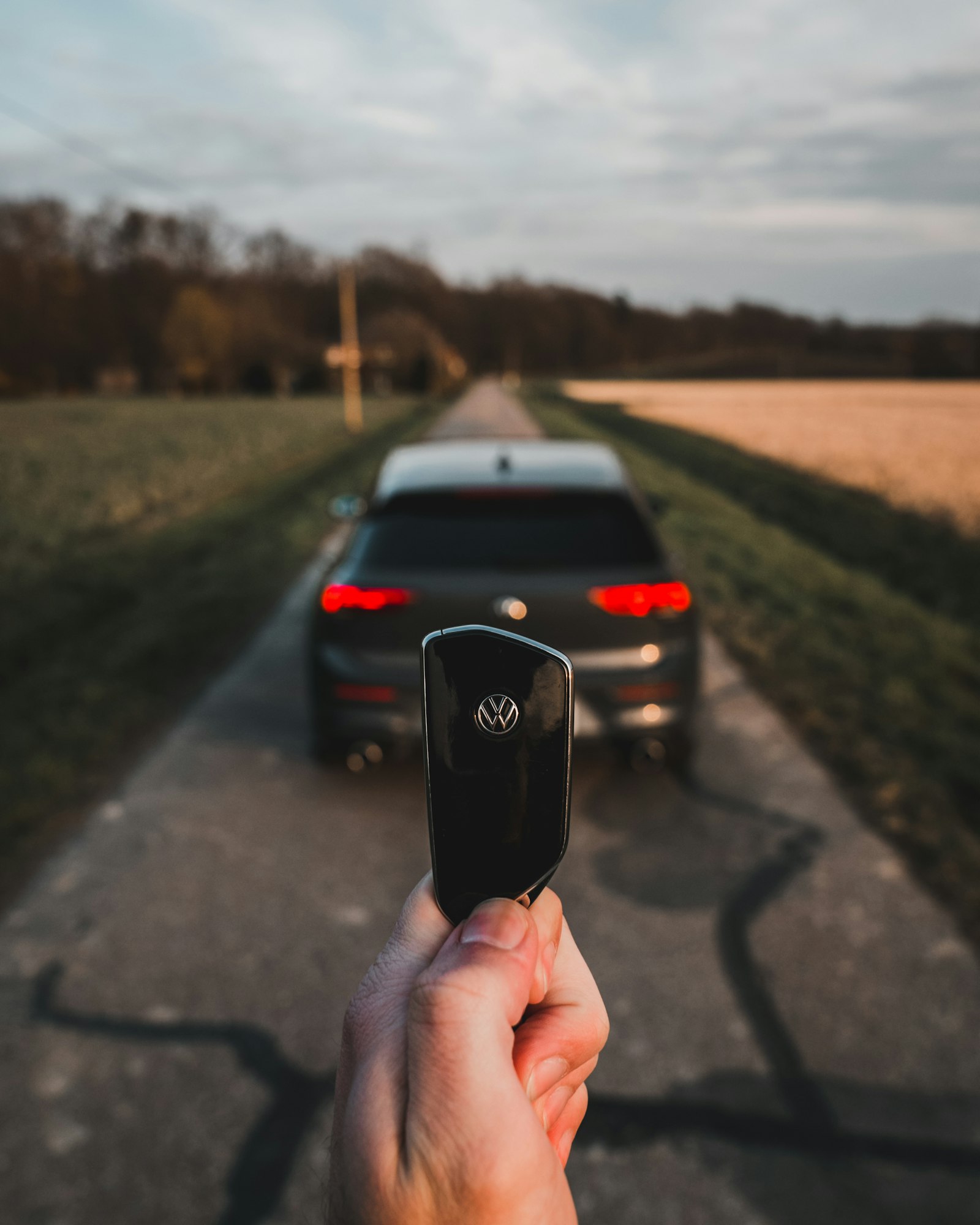 Person holding a phone with a car on the road ahead